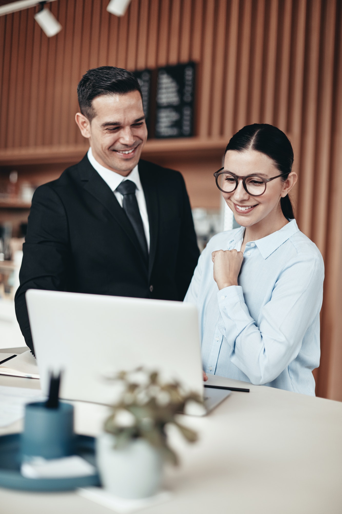 two-smiling-businesspeople-using-a-laptop-together-in-an-office.jpg